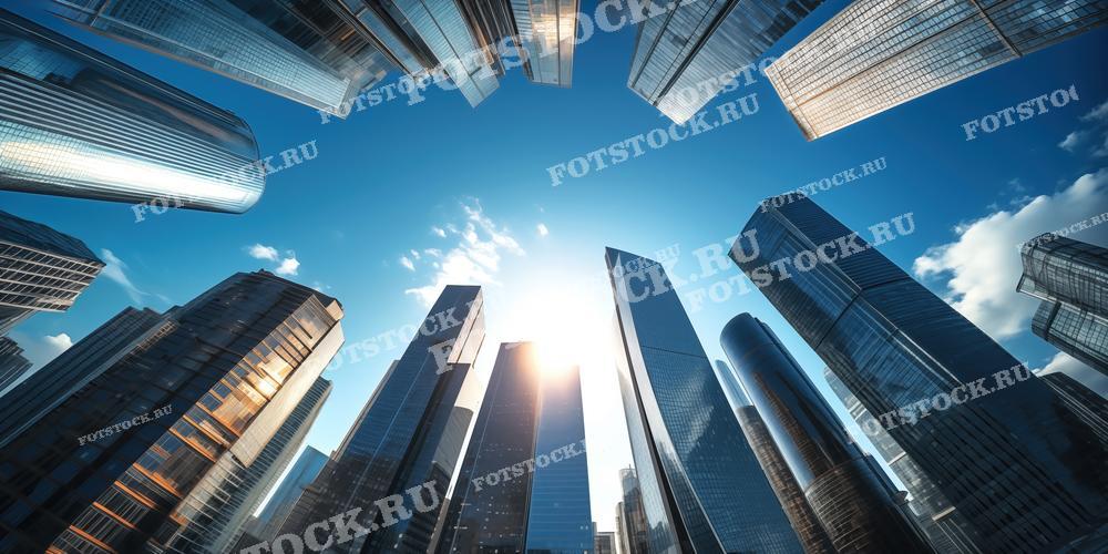 На фотографии изображены современные небоскребы, снятые снизу вверх на фоне голубого неба. Высотные здания с зеркальными фасадами отражают свет и создают впечатляющую композицию. Архитектура небоскребов характеризуется современными материалами и инновационным дизайном. Это изображение отлично подойдет для использования в материалах, связанных с городской архитектурой, строительством и бизнесом, а также для иллюстраций в журналах и рекламных буклетах.