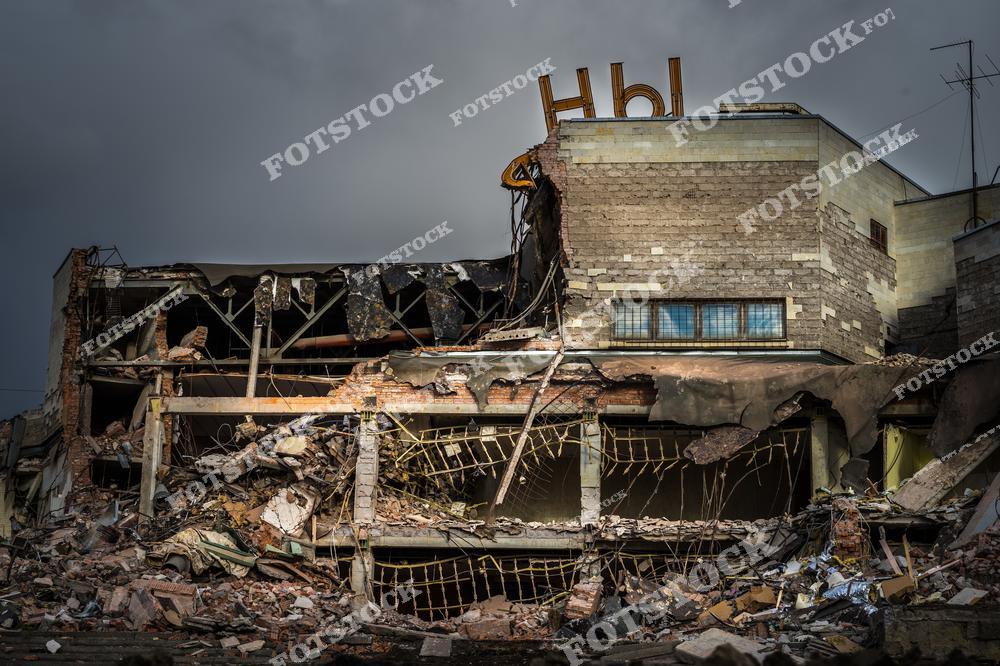 На фотографии изображено здание, сильно поврежденное в результате разрушения. Обвалившиеся стены и остатки конструкции подчеркивают масштаб произошедшего. Снимок иллюстрирует последствия разрушительных событий и упадок городской архитектуры.