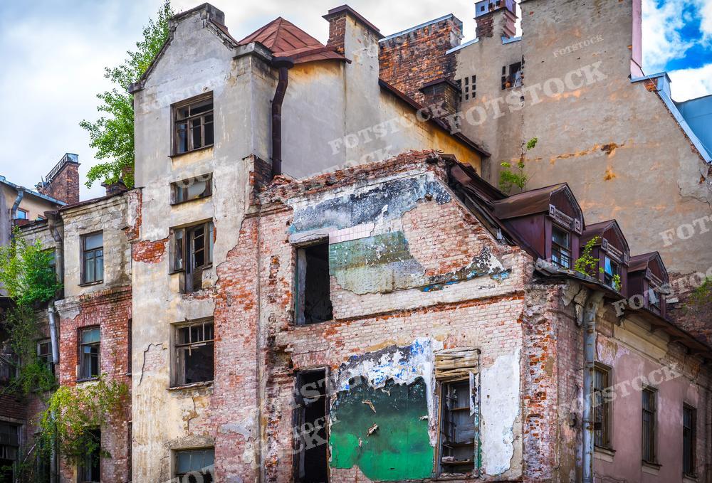 Осыпающаяся штукатурка, разрушенные кирпичи, заколоченные двери и окна, все это говорит о длительной заброшенности. Растения, прорастающие сквозь стены и крыши, добавляют ощущения забвения и природы, забирающей обратно занятые пространства. Такой кадр может быть использован в исторических исследованиях, документальных фильмах о городской среде или как визуальный призыв к сохранению архитектурного наследия.