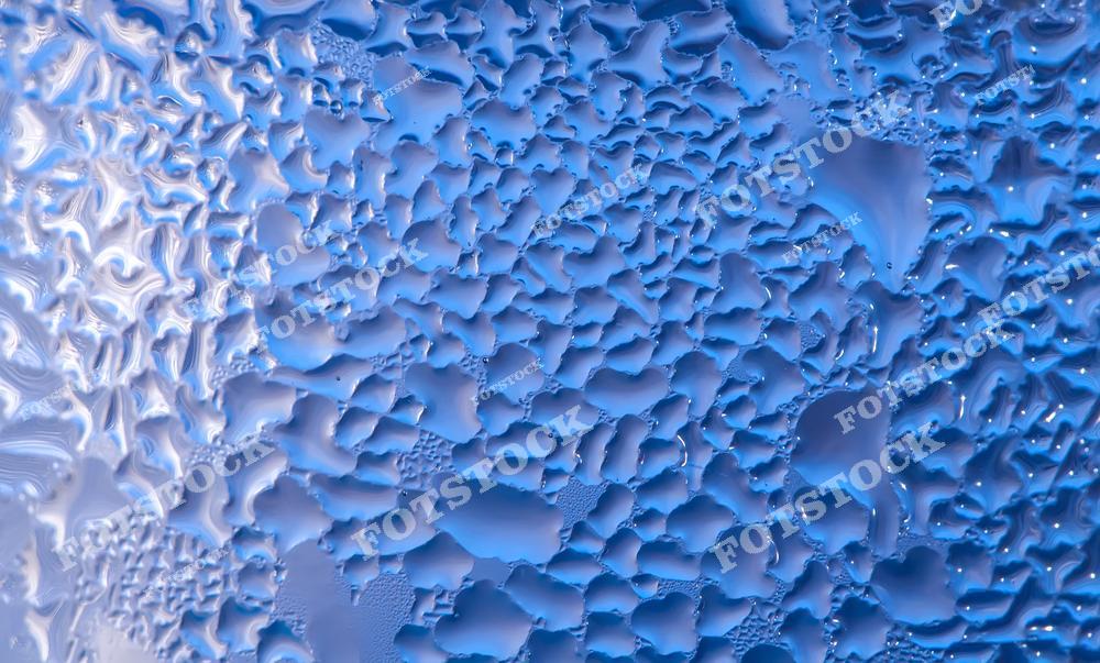 Фотография капель воды, сгруппированных в уникальный узор на светло-синем фоне. Капли различной формы создают абстрактную текстуру, напоминающую замерзшую поверхность или конденсат. Изображение передает ощущение прохлады и подходит для использования в абстрактном дизайне.