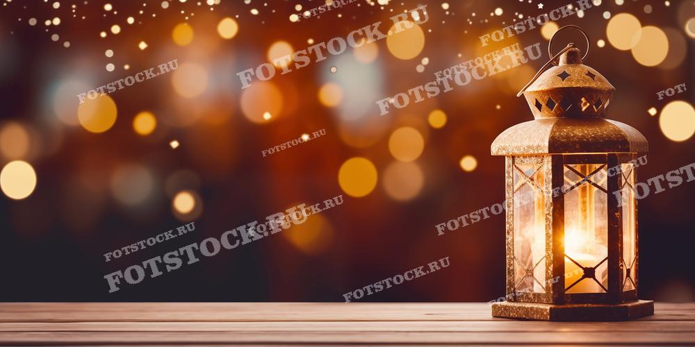На фотографии изображен старинный фонарь, освещающий деревянный стол на фоне размытого золотистого и коричневого боке. Свет фонаря создает теплую и уютную атмосферу, напоминающую о зимних праздниках или уютных вечерних посиделках. Этот фон идеально подходит для использования в праздничных открытках, дизайне приглашений, рекламных материалов, а также для создания уютного декора в интерьерах.