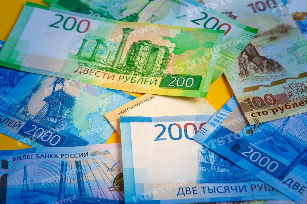 На фотографии изображены разноцветные банкноты российского рубля номиналом 200, 2000 и 100 рублей, расположенные внахлест друг на друга. Купюры выглядят новыми, с яркими, четкими изображениями. Такая фотография может быть использована для статей и обучающих материалов о российской валюте, экономических аналитических материалов, блогов о финансах и инвестициях, а также в рекламных и маркетинговых материалах, связанных с финансовой тематикой.