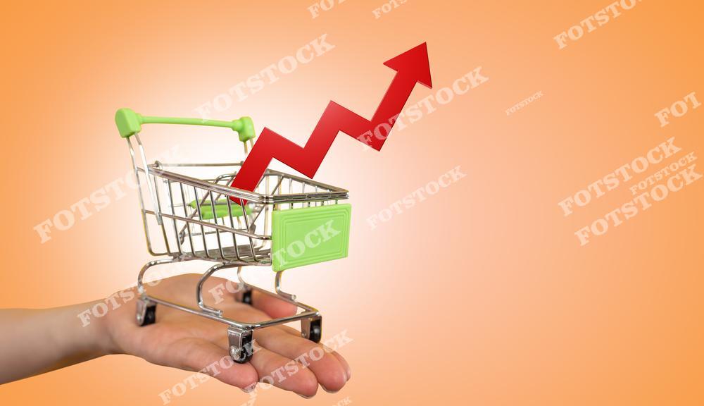 На фотографии изображена миниатюрная тележка с продуктами, с фоном, на котором изображена стрелка, символизирующая рост инфляции. График, отражающий увеличение цен на продукты питания, подчеркивает текущие экономические тенденции.