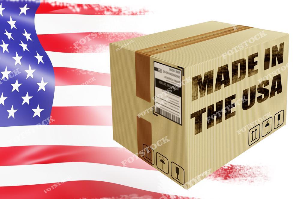 На изображении показана картонная коробка с надписью "Made in the USA", стоящая на фоне флага США. Фотография символизирует продукцию, произведённую в Америке, и ассоциируется с качеством и национальной гордостью. Этот образ подчёркивает происхождение товара и его соответствие американским стандартам.