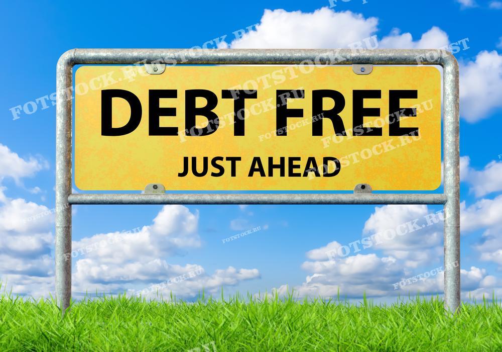 Дорожный знак с надписью "Debt Free" на фоне яркого голубого неба с облаками. Символизирует приближение финансовой свободы и отсутствие долгов, ассоциируется с темой финансовой грамотности.