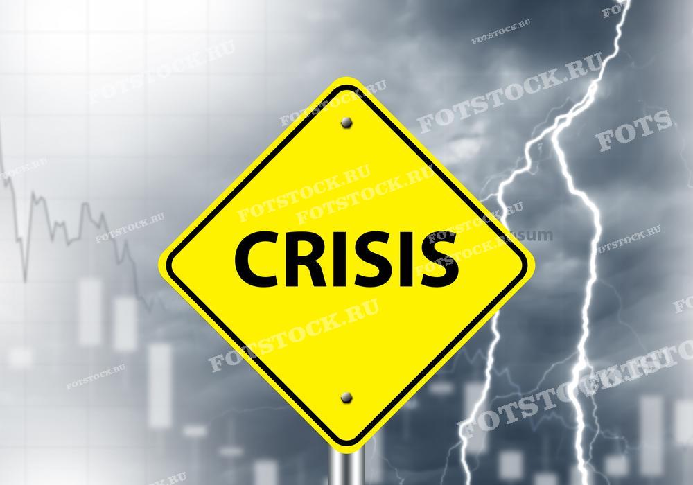 На изображении представлен желтый знак с надписью "Crisis" на фоне грозового неба и падающих графиков. Эта композиция символизирует финансовый кризис и нестабильность в экономике. Молнии и темное небо подчеркивают драматизм и серьезность ситуации. Графики указывают на ухудшение финансовых показателей.