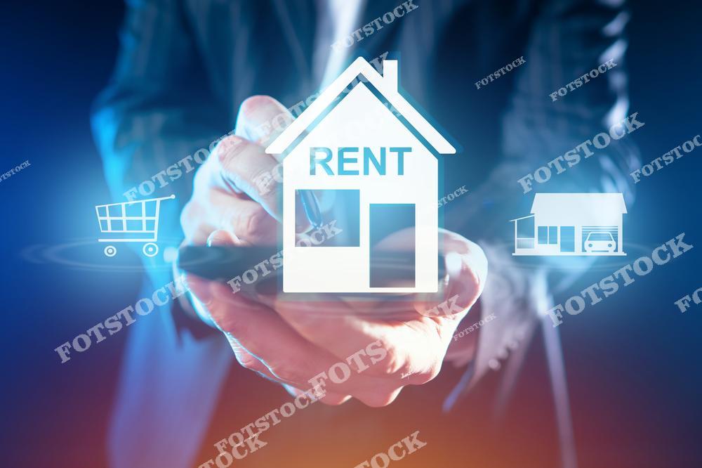 На изображении символ дома с надписью "Rent" в руках бизнесмена, держащего телефон. По бокам также расположены иконки, связанные с покупками и недвижимостью. Иллюстрация отражает концепцию аренды, управления недвижимостью и использования цифровых технологий в сфере недвижимости.