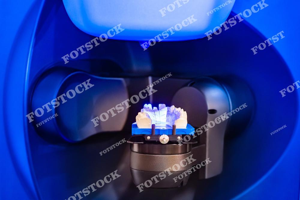 Фотография демонстрирует современное стоматологическое оборудование для 3D-моделирования зубов. Устройство используется для создания точных протезов и имплантатов. Инновационные технологии помогают повысить качество стоматологического лечения.