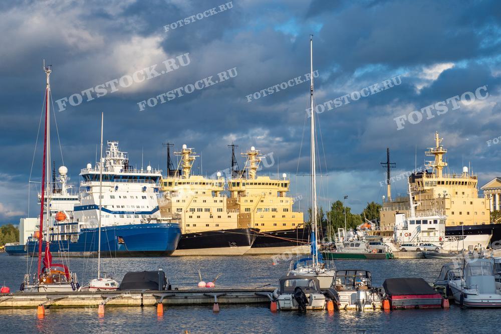 На фотографии изображена морская гавань в Хельсинки, Финляндия. Видно несколько кораблей, пришвартованных у пирса. Среди них есть рыболовецкие суда и траулеры, а также несколько небольших яхт на их фоне. Этот красивый морской пейзаж дополняется городскими причалами и застройкой на заднем плане, что создает живописное сочетание городской и морской атмосферы.

Фотография может быть использована для иллюстрации статей о морском транспорте, рыболовстве или туристических путеводителях по Хельсинки. Также она подойдет для украшения стен в кафе или ресторанах, специализирующихся на морской кухне, а также для использования в образовательных материалах о Финляндии или морской индустрии.