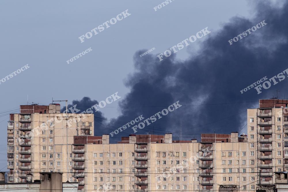 На фотографии изображен густой черный дым, поднимающийся над жилыми домами. Дым от пожара подчеркивает серьезность чрезвычайной ситуации и ее влияние на город.