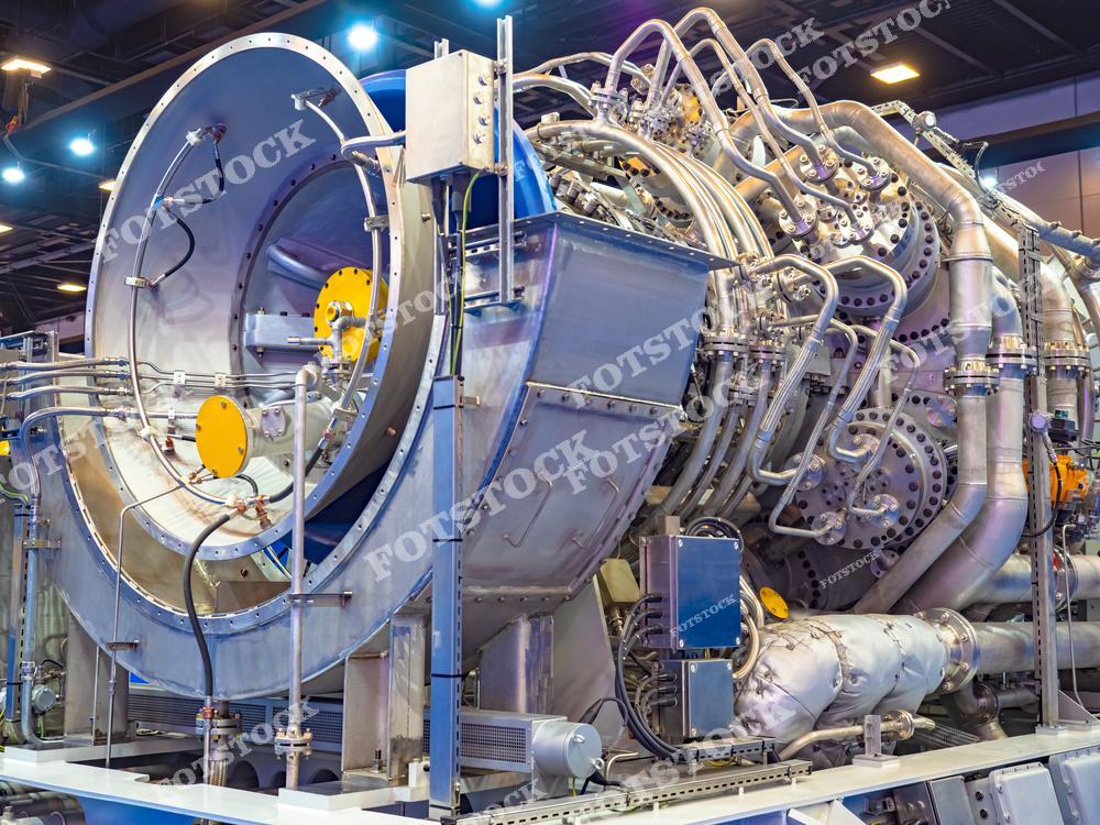 На изображении представлен промышленный газотурбинный агрегат с множеством трубопроводов, патрубков и технологических соединений. Такая установка используется для генерации энергии, в авиации, нефтегазовой или теплоэнергетической промышленности. Снимок демонстрирует передовые достижения в области машиностроения и энергетических систем.
