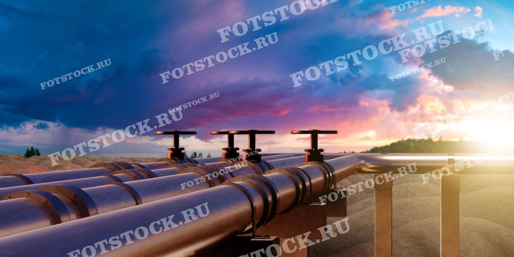 На фотографии изображен трубопровод, простирающийся вдоль природного ландшафта на фоне заката. Снимок подчеркивает важность трубопроводных систем в транспортировке нефти и газа, а также гармонию инженерных сооружений с окружающей природой. Атмосферный закат добавляет драматизма и красоты индустриальному пейзажу.