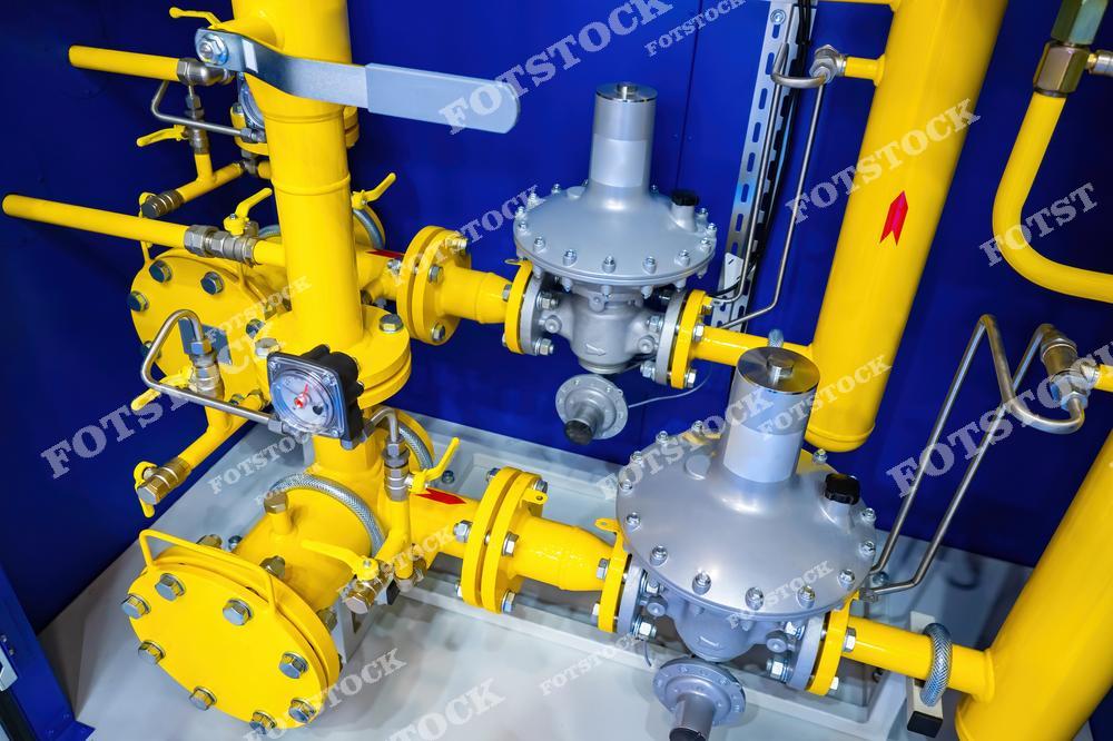 На фото показано газораспределительное оборудование с измерителем давления, установленным на газопроводе. Желтые трубы с заглушками и клапанами обеспечивают безопасную эксплуатацию системы, а автоматический пункт контроля топлива используется для мониторинга и регулировки подачи газа.