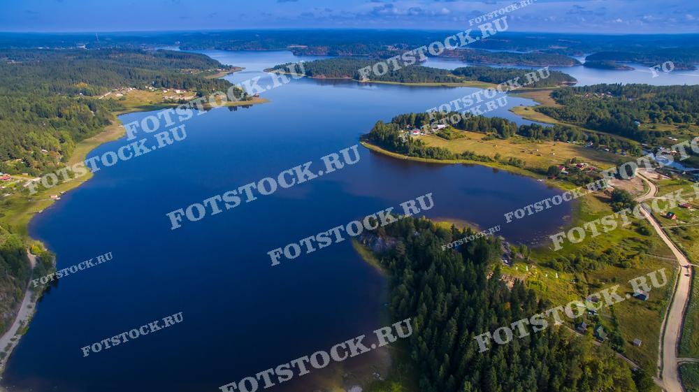На фотографии запечатлен живописный вид на один из карельских водоемов и его окрестности с высоты. Леса и небольшие деревни окружают озеро, создавая идиллическую картину карельской природы. Дорога, проходящая вдоль берега, соединяет деревни, позволяя путешественникам наслаждаться красивыми видами на воду и леса. Этот уголок Карелии прекрасно отражает гармонию между природой и человеком, делая его привлекательным для тех, кто ищет спокойствия и умиротворения.