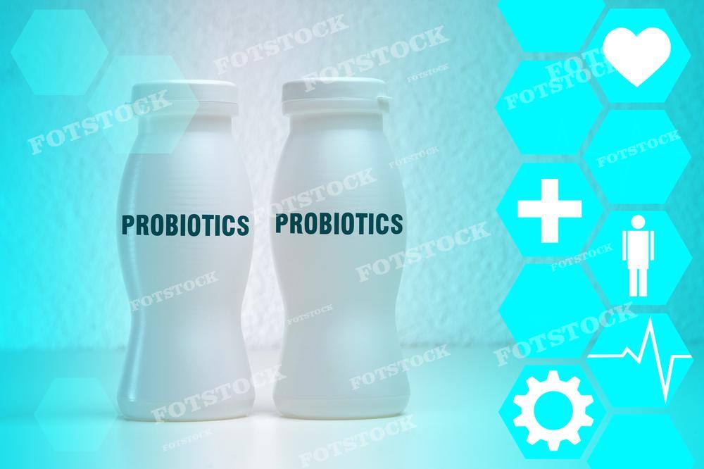 На фото изображены две бутылки с надписью "PROBIOTICS" на светлом фоне с гексагональными узорами и иконками здоровья, такими как сердце, плюс, фигурка человека и зубчатое колесо, символизирующие здоровье, медицинскую помощь и благополучие. Этот снимок может использоваться в маркетинговых и образовательных материалах, связанных со здоровьем кишечника, влиянием пробиотиков на организм и продвижением здорового образа жизни.