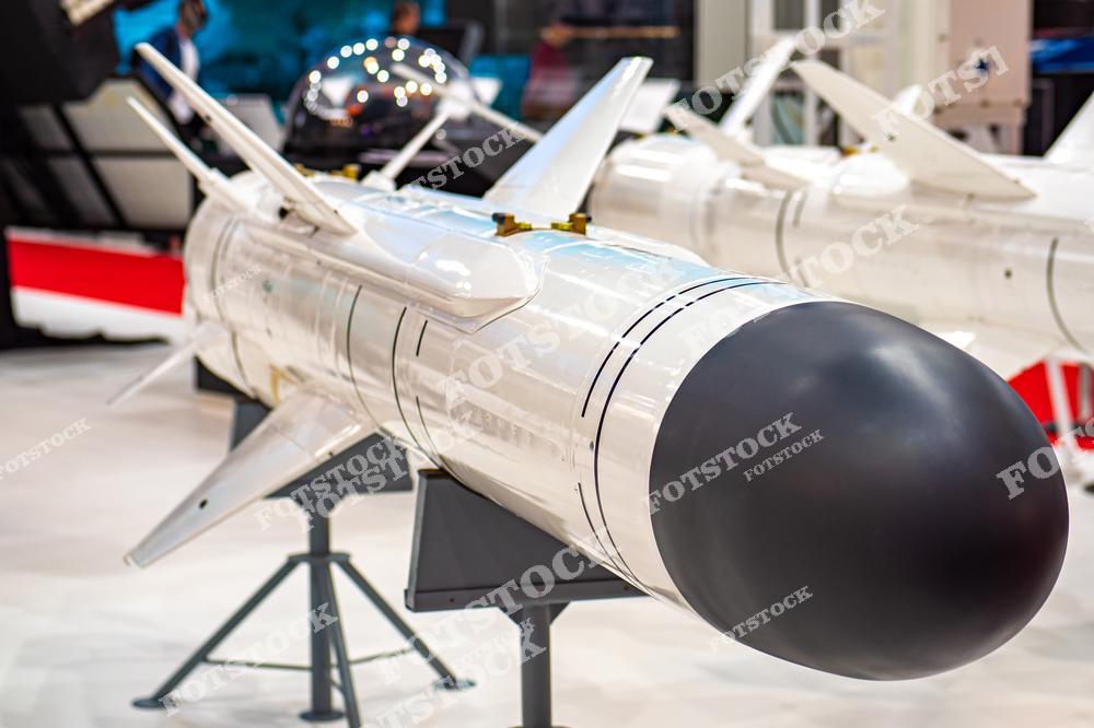 На фотографии изображена современная управляемая ракета, представленная на выставке военной техники. Ракета демонстрирует передовые технологии в области вооружений и авиации. Она установлена на стенде для обозрения публики.