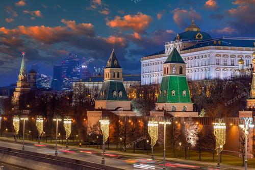 На снимке изображен Московский Кремль на фоне новогодних гирлянд и светящихся украшений.  Эта фотография подходит для иллюстрации статей о зимнем отдыхе в Москве, а также может использоваться в туристической рекламе или каталогах автомобильных маршрутов по столице.