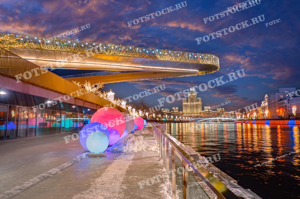 На фотографии изображена Москва в праздничный зимний вечер.  Этот ракурс отражает современное художественное видение города, что делает фотографию идеальной для использования в материалах о городской культуре, современном искусстве и туристических проспектах.