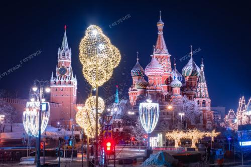 На фотографии представлена захватывающая панорама Москвы с Кремлем и Красной Площадью в центре внимания. Заснеженные крыши и новогодние украшения создают волшебную атмосферу перед Рождеством. Изображены символы России - Московский Кремль и Храм Василия Блаженного. Фотография может стать идеальной иллюстрацией для печатных материалов, рассказывающих о культурных богатствах России и праздновании новогодних праздников в столице.