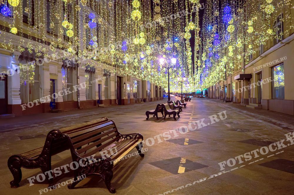 На фотографии изображена новогодняя иллюминация в Москве. Светящиеся гирлянды и украшения создают праздничное настроение в ночное время. Фотография подходит для использования в материалах о новогодних праздниках, туристических буклетах и статьях о зимней Москве.