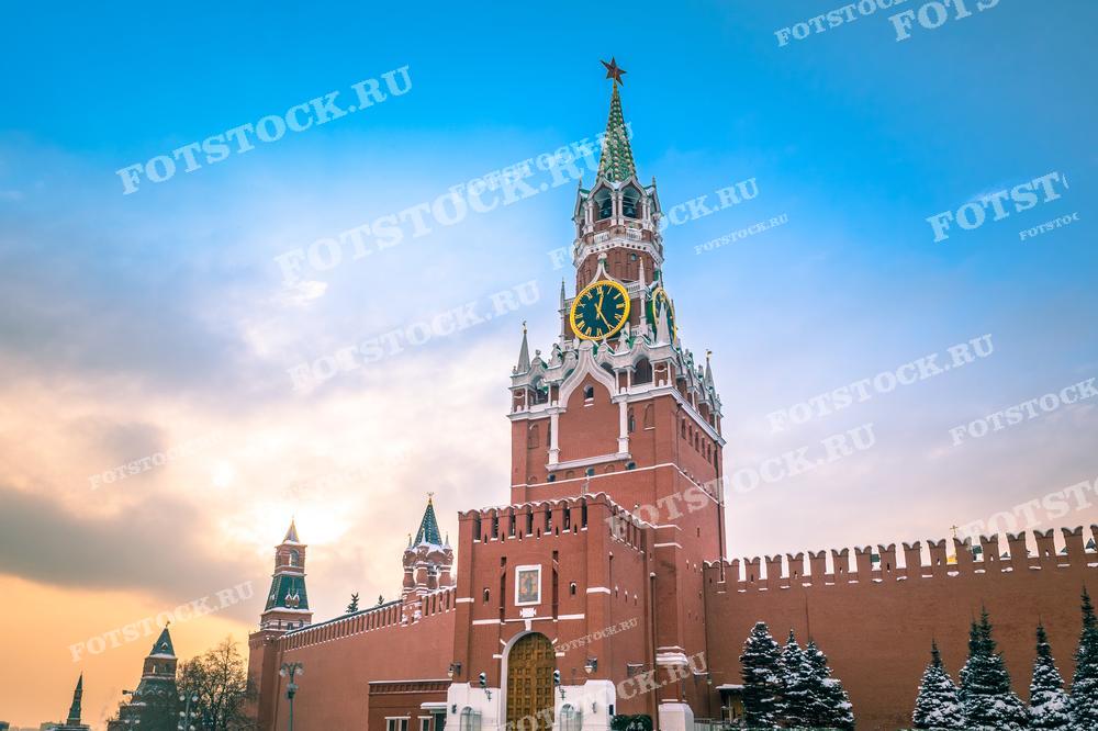 На фотографии изображена знаменитая Спасская башня Кремля в Москве. Этот символический объект архитектуры выделяется курантами и красной звездой на шпиле. Зимний вечер добавляет к сцене особенное очарование, подчеркивая характерный силуэт стен Кремля на фоне закатного неба. Эта фотография идеально подходит для использования в материалах, связанных с российской историей и культурой, в туристических брошюрах и как визуальное украшение статей о Москве.