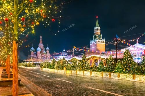 Красная площадь превращается в сказочное пространство с Рождественским базаром и огнями Кремлевских стен. На фотографии запечатлено умиротворенное Рождество в столице, с ее красочными лавками и украшениями, создающими атмосферу праздничной сказки.

Фотография идеально подходит для рекламы рождественских мероприятий, туристических брошюр, а также для декорирования праздничных материалов. Она может стать невероятным дополнением к статьям о традициях Рождества в Москве и использоваться в культурных публикациях.