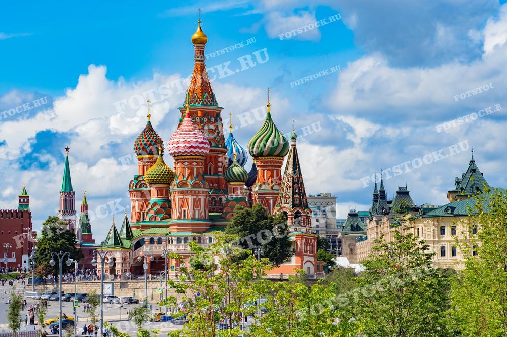На фотографии изображен Собор Василия Блаженного на Красной площади в Москве, один из самых известных и узнаваемых символов России. Собор выделяется своей яркой цветовой палитрой и уникальными луковичными куполами. Этот вид включает также части Кремля и исторические здания в окружении, что добавляет культурной и исторической ценности кадру. Фотография подходит для использования в образовательных материалах, туристических брошюрах и как элемент украшения, иллюстрирующий российскую культуру и архитектуру.
