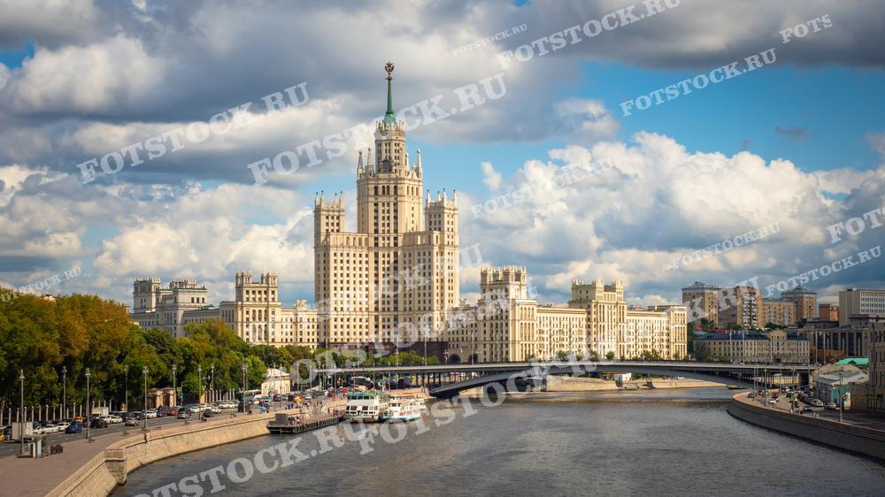 На фотографии изображена высотка на Котельнической набережной в Москве, одна из семи сталинских высоток, являющаяся значимым символом архитектурной эпохи середины XX века. Это здание возвышается на берегу Москвы-реки, окруженное улицами и мостами, что подчеркивает динамику и масштабность городского ландшафта. Эта фотография может использоваться в различных публикациях, посвященных архитектуре, истории Москвы или городскому планированию, а также в туристических брошюрах и культурно-исторических материалах.