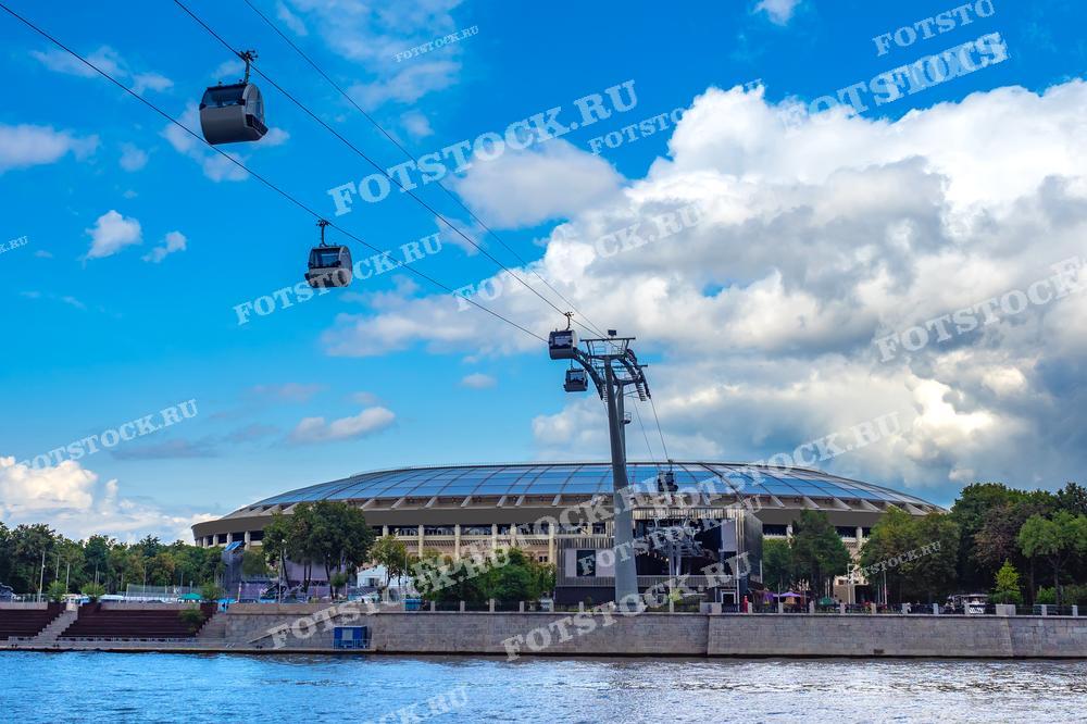 На фотографии изображены канатная дорога и стадион Лужники в Москве. Лужники — это крупнейший стадион России, часто используемый для проведения крупных спортивных и культурных мероприятий.