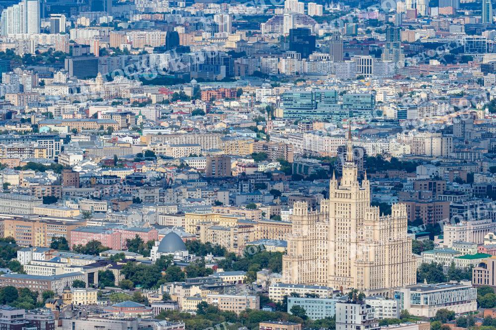 На фотографии представлен вид сверху на одну из известных сталинских высоток — Министерство иностранных дел Российской Федерации, расположенное в центре Москвы. Это здание является одним из семи знаменитых "сестёр", построенных в сталинском стиле, и выделяется своим величественным и монументальным видом. Фотография демонстрирует контраст между старинной архитектурой и окружающими его более современными зданиями, подчеркивая богатую архитектурную историю Москвы. Это изображение подходит для использования в исторических и архитектурных изданиях, образовательных материалах и публикациях о городском развитии.