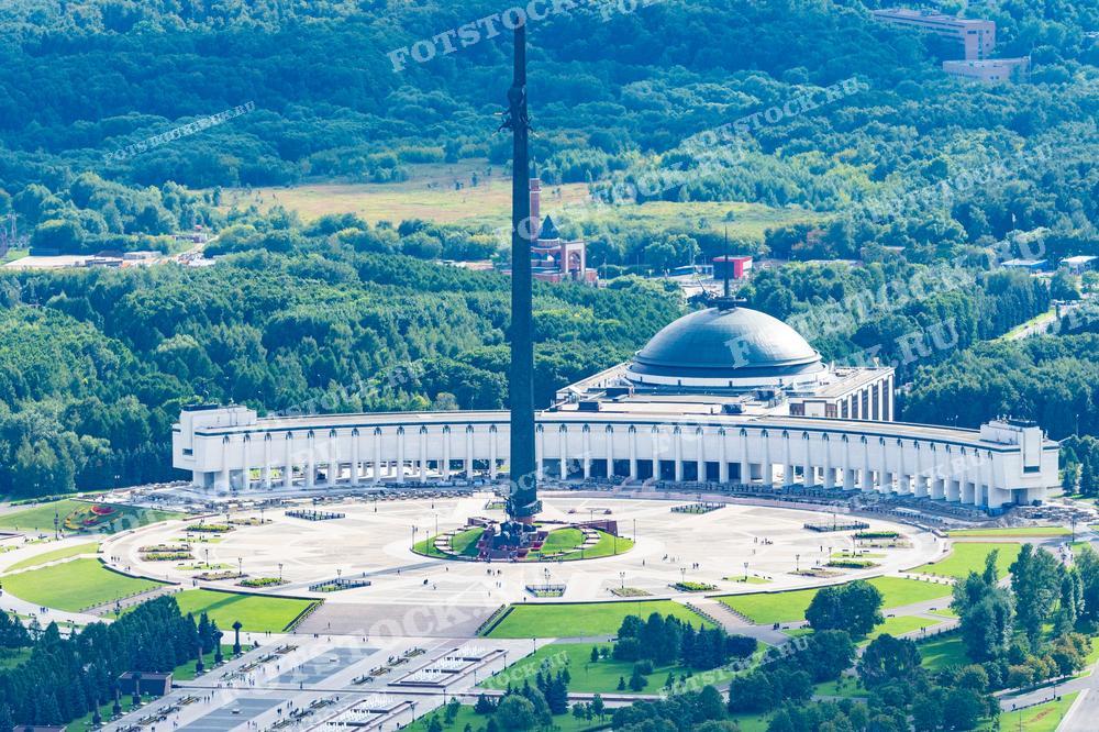 Фотография показывает величественный вид на Парк Победы, расположенный на Поклонной горе в Москве. На переднем плане видна русская архитектура мемориальных комплексов, а в дальнем плане открывается столичный пейзаж с высоты горы. Этот снимок иллюстрирует красоту и значимость места, символизируя память о победе в Великой Отечественной войне. Фотографию можно использовать для иллюстрации путеводителя по Москве, статьи о исторических местах России, а также в рекламных материалах, привлекающих туристов в столицу.