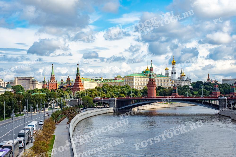 Фото показывает панораму центра Москвы с его историческими кремлёвскими стенами, башнями, церквями и Большим Кремлёвским дворцом. Эта фотография может быть использована в качестве материала для туристических брошюр, исторических изданий и образовательных ресурсов.
