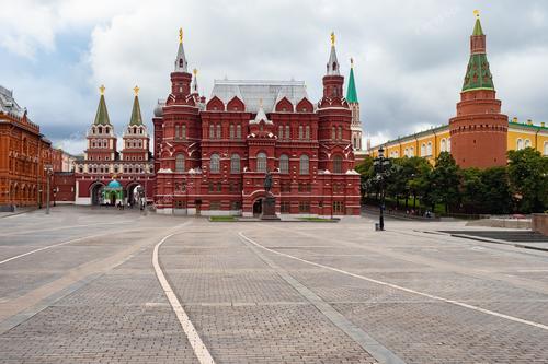 Фотография показывает площадь у Кремля с видом на архитектурные шедевры, окружающие Красную площадь. Это отражение богатства российской столицы, где историческое наследие встречается с современностью. Вид на музеи и здания центра Москвы в солнечный день подчеркивает красоту русской архитектуры и культурного наследия. Фотография может использоваться в туристических брошюрах, гиде по музеям, а также в материалах о культурных достопримечательностях России.