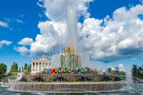 На фотографии запечатлен фонтан "Каменный цветок", являющийся одной из достопримечательностей Центральной аллеи ВДНХ в Москве. Этот фонтан известен своей оригинальной архитектурой, в которой используются мозаичные элементы из смальты и кусочки цветного стекла, создавая красочные композиции на фоне облаков. Фотография иллюстрирует архитектурное наследие выставки достижений народного хозяйства и привлекательность для туристов и путешественников, совершающих летние поездки в Москву.
Это изображение может использоваться в туристических брошюрах, путеводителях по Москве, рекламных материалах о городе и архитектурных объектах, а также для создания постеров и открыток.