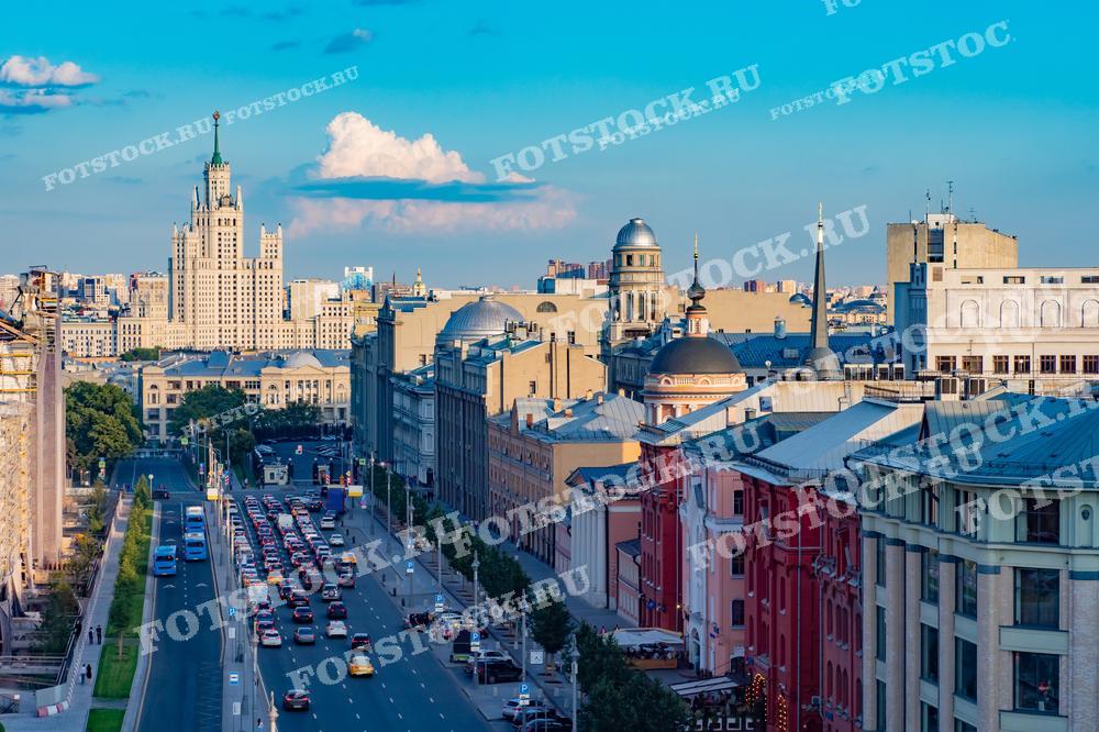 На фотографии изображён вид одной из центральных улиц Москвы. На заднем плане видно высотное здание в стиле сталинского ампира. Это изображение демонстрирует динамичную городскую жизнь с активным движением транспорта и разнообразной архитектурой, что характеризует Москву как современный, активно развивающийся мегаполис. Такие фотографии отлично подойдут для использования в туристических каталогах, журналах о путешествиях, а также в образовательных материалах и научных статьях о развитии городской инфраструктуры и архитектуры.