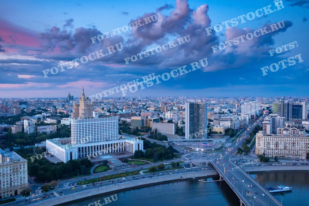 Фотография центральной части Москвы с высоты, включающая Дом Правительства Российской Федерации и вид на городские дороги и мосты. Подходит для использования в материалах о городской инфраструктуре, правительственных учреждениях и архитектуре Москвы.