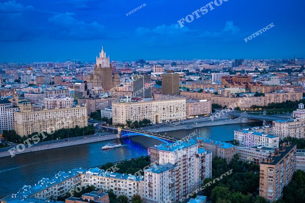 На фото изображен захватывающий вид на Москву с линии горизонта, где отражаются основные архитектурные элементы города, включая набережную Москвы-реки и мосты. В кадре также видны здания российской столицы, составляющие её уникальный городской ландшафт. Мосты Москвы, соединяющие берега реки, добавляют динамичности пейзажу, а прогулка по Москве-реке становится отличной возможностью увидеть столицу с необычного ракурса.