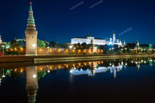 Ночной вид на Московский Кремль с берега Москвы окутан мистической атмосферой. Грандиозный Кремлевский дворец и другие исторические здания подсвечены слабым светом, создавая неповторимую панораму. Освещенные архитектурные шедевры и отражения в воде реки создают впечатляющий вид, который иллюстрирует богатство и красоту Москвы в ночное время. Эта фотография может быть использована для создания туристических буклетов, рекламы экскурсий по Москве и рекламы туристических агентств, а также для иллюстрации статей и книг о достопримечательностях России.