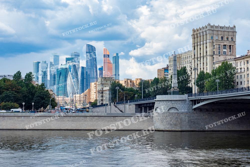 На фотографии изображены современные здания делового центра Москва-Сити и набережная Москвы-реки. Фото можно использовать для иллюстраций, рекламы и туристических материалов.