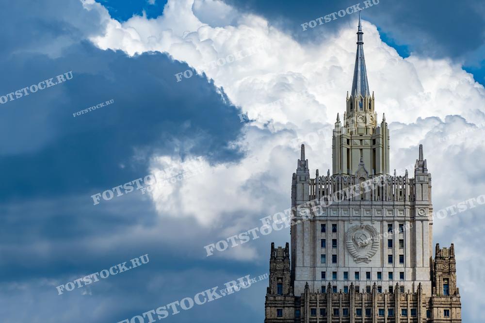 На фотографии изображена одна из знаменитых сталинских высоток — Министерство иностранных дел России. Этот кадр выделяется захватывающим видом здания на фоне драматичного облачного неба, подчеркивающего монументальность и грандиозность советской архитектуры. Это изображение идеально подходит для использования в статьях и публикациях о советской архитектуре, истории Москвы, или как визуальный материал в учебных пособиях по архитектуре.