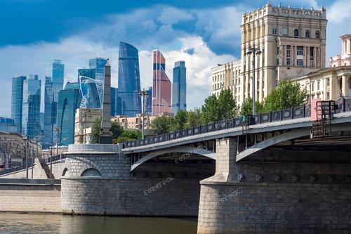 На фотографии запечатлен мост Бородино и высотные здания в центре российской столицы. Архитектурные шедевры и высотные здания олицетворяют собой современный облик Москвы, ее стремление к развитию и процветанию. Эта фотография может быть использована в туристических брошюрах, рекламе экскурсий по Москве и статьях о городской архитектуре и туризме.