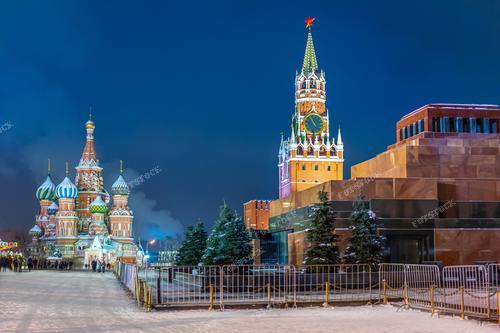 Представьте себе картину зимнего вечера в Москве. На фоне снега высится монументальный Мавзолей, символизирующий силу и величие прошлого. За ним  располагается древний Кремль, воплощение истории и власти. А дальше, словно сказочный храм, возвышается многовековой собор Василия Блаженного. Эта фотография пригодится как иллюстрация для изучения истории России и ее культурного наследия. Она также может быть использована для туристических брошюр или рекламы, привлекая внимание к красоте российской столицы в зимнее время.