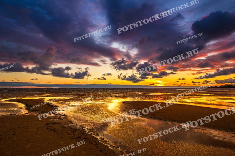 На фотографии изображено закатное небо над Чудским озером. Яркие краски заката отражаются в воде. Это изображение подчеркивает красоту природы и магию вечернего света.