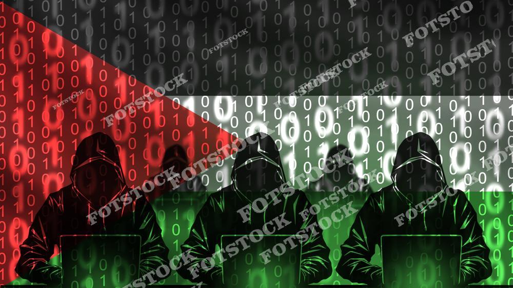 На изображении показаны фигуры хакеров в капюшонах, работающих за ноутбуками, на фоне флага Палестины, переплетенного с бинарным кодом. Фотография символизирует вызовы кибербезопасности, глобальные угрозы и роль технологий в современном мире.