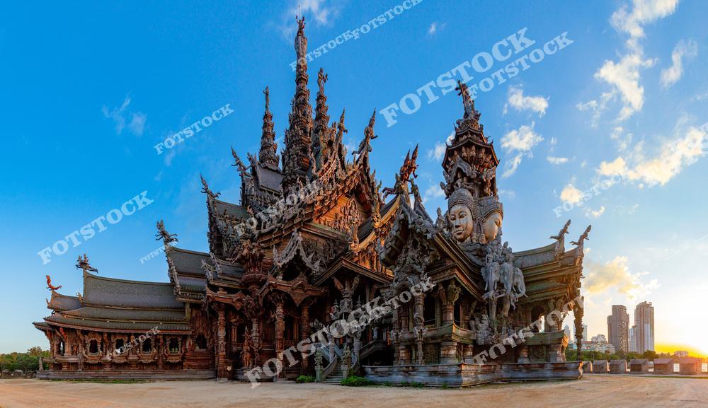 На фотографии изображён Храм Истины — грандиозное религиозное сооружение, выполненное полностью из дерева и покрытое детализированной резьбой. Храм расположен на берегу Сиамского залива в Паттайе, Таиланд, и представляет собой синтез философии, искусства, культуры и религии. Эта фотография отражает богатство азиатской архитектуры и духовного наследия.