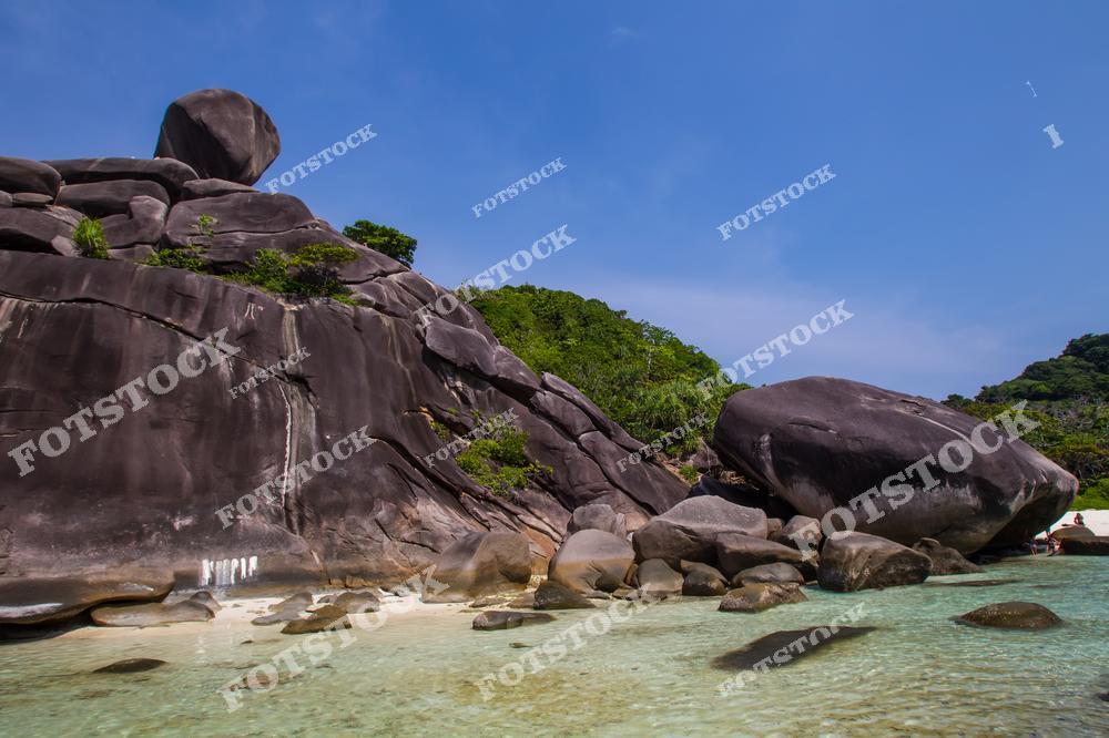 На фото — знаменитая скала Парус (Sail Rock), расположенная на одном из Симиланских островов в Таиланде. Гладкие тёмные гранитные валуны резко контрастируют с белоснежным песком и бирюзовой водой. Это место — один из самых узнаваемых природных объектов в Таиланде, популярное среди туристов, фотографов и любителей снорклинга.