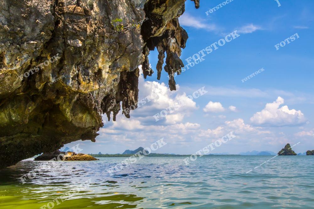 На фото изображены впечатляющие скалы с водными пещерами в заливе Пханг Нга, омываемые чистой бирюзовой водой. Природные образования и живописный морской пейзаж создают атмосферу уединения и красоты, характерную для этого экзотического уголка Таиланда.