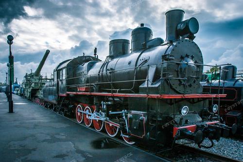 Эта великолепная фотография представляет собой черный ретро-паровоз, сливающий в себе элегантность старины и уникальное искусство инженерной техники. Изогнутые линии и выразительная текстура делают этот паровоз поистине визуальным шедевром. Фотография открывает взгляд на прекрасное сочетание мощи и изящества.

Идеально подходит для использования в исторических публикациях, статьях о техническом искусстве, журналах о железнодорожной индустрии, а также в качестве декора в музеях и выставках ретро-техники.