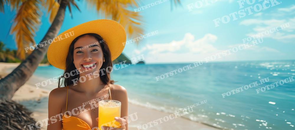 На фотографии изображена улыбающаяся молодая женщина в шляпе, стоящая на пляже с коктейлем в руках на Пхукете, Таиланд. Вокруг раскинулся живописный вид с пальмами, белым песком и голубым морем. Этот снимок подчеркивает радость и беззаботность летнего отдыха на пляже.