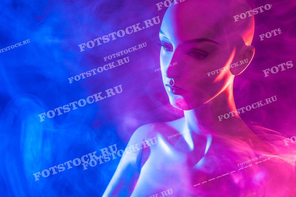 Фотография показывает манекен в дыму на фиолетово-синем фоне. Это изображение символизирует загадочность и искусство, создавая атмосферу таинственности и эстетики.